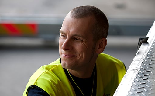 Mondi worker at Dynäs holding up paper for quality inspection.